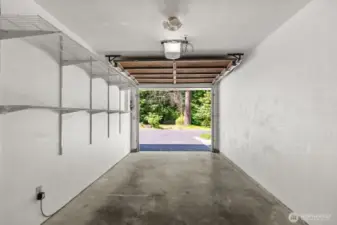 The garage comfortably parks one car and includes built-in shelving, perfect for organizing tools and storage.