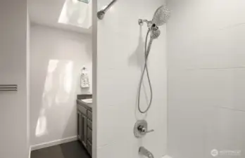The guest bathroom was just recently refreshed with a new bathtub, fixtures, and a tile surround.
