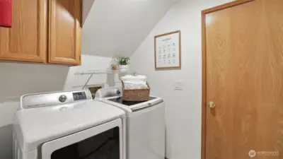 Utility room with upper cabinets. The newer washer and dryer remain.