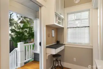 This built-in desk is the command center of the home and features a charging station for lots of items.  That door opens to the back yard patio for outdoor entertaining.