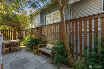 The back yard is so charming! The whole back area is pavers for usable patio with space for a dining table and seating.  A fountain fills the air with the soothing sound of trickling water.