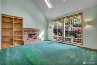 Family room with fireplace, vaulted ceiling, skylights.
