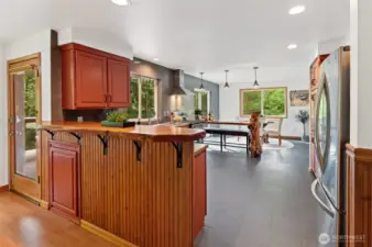The kitchen features a unique live-edge bar, anchored by a tree. Watch nature as you do the dishes.
