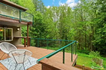 The large entertainment deck overlooks the backyard and trees. It features a built-in bar area to sit and take in the trees.