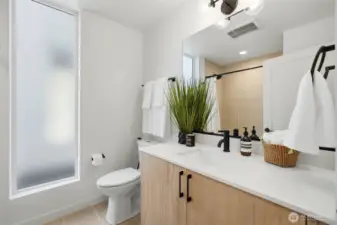 Second-floor full bathroom with tile flooring, bathtub/shower combination, quartz vanity, and modern fixtures located between the two bedrooms.
