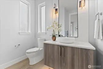 A beautifully styled powder bath with designer lighting, elevated finishes, and a modern vanity that turns a functional space into a design moment.