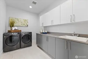 Beautifully positioned with direct access from the walk-in closet and additional hall entry, the laundry room delivers elevated utility with seamless connection to the primary suite and everyday living beyond.