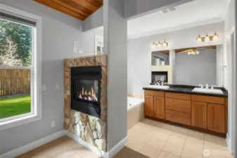 Primary bedroom with en-suite bath, jetted tub and walk in shower. Double sided propane fireplace adds the perfect ambiance to a nice soak in the jetted tub