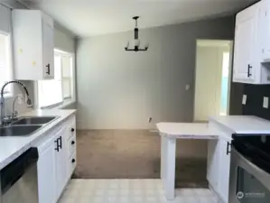 A Different View showing the Dining Room and Nice Size Kitchen with Newer White Painted Cabinets, Newer Stainless Appliances, Skylight, Newer Stainless Sink and Faucet.