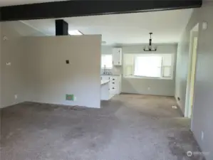 View of the Newer Painted Living Room from the Front Entry Door Showing the Dining Room and Newer Carpeting.