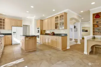 The kitchen seamlessly extends from the gathering room, featuring a spacious layout with a central island, granite countertops...