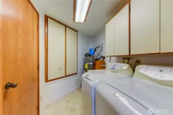 Brightly lit utility room with full-size washer/dryer and utility sink for pets or messy projects.