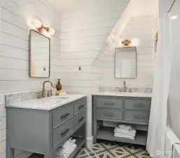 Shared hall bathroom with shiplap, two vanities, cement tile flooring and bathtub with gold fixtures.