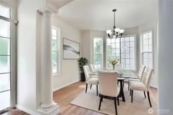 Dining area with architectural details and bay windows.