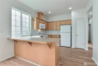 A pantry closet is adajcent to the fridge.