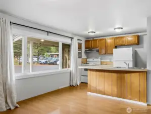 Kitchen, lliving area combo with a bar space for eating.