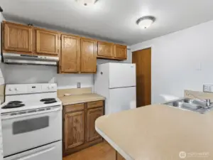 Kitchen, lliving area combo with a bar space for eating.