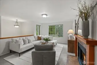 The living room serves as the heart of the home, offering a warm and inviting atmosphere centered around a charming wood burning fireplace, and featuring a large picture window looking out into the cul-de-sac and beyond.