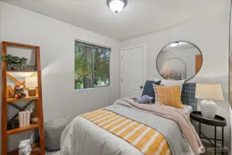 The second inviting main-floor bedroom with a sun-filled window and a generous walk-in closet.