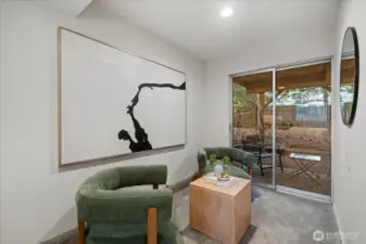 View of the sitting area with slider out to patio and fully fenced backyard off of the third bedroom.