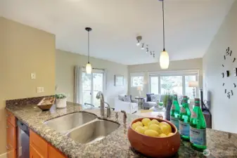 A view of the living/dining area from the kitchen with granite countertop.