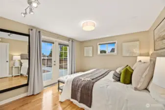 Primary bedroom with French doors to the large deck.