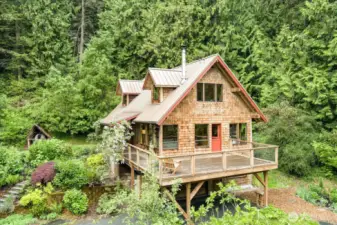 Craftsman cottage in the woods but surrounded by bountiful gardens.