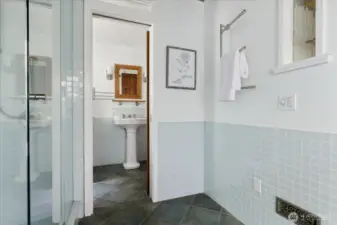 Looking through to pedestal sink and toilet with pocket door between.