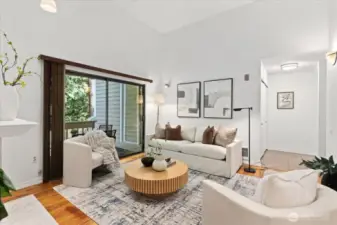 Bright living room with vaulted ceilings, skylights, and cozy fireplace.