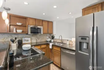 Updated kitchen with stainless appliances and stone counters.