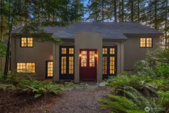 Welcoming front entrance framed by towering native trees in this distinctive home blending Mediterranean inspired architecture with the rustic charm of the Pacific NW.