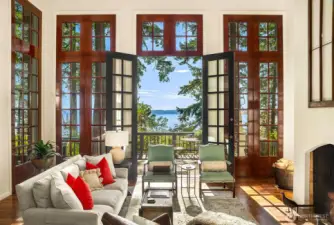 Open concept living room with welcoming wood burning fireplace and French door access to entertainment sized deck.