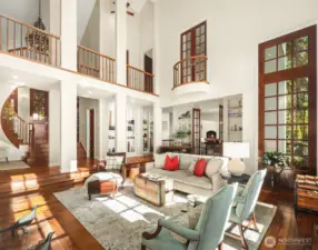 Juliet balcony from Second primary bedroom opens to grand living room with open upper walkway.