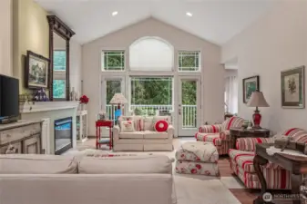 Bright and spacious living area with vaulted ceilings and rich hardwood floors.