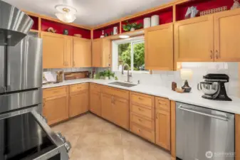 Large kitchen with upgraded silestone countertops and beautiful new backsplash. Stainless appliances with a fabulous induction stove! The kitchen window looks over the beautiful backyard.