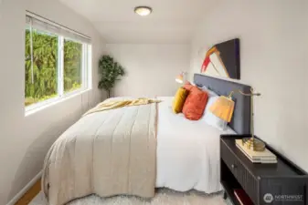 Another view of the primary bedroom which includes a ceiling fan.