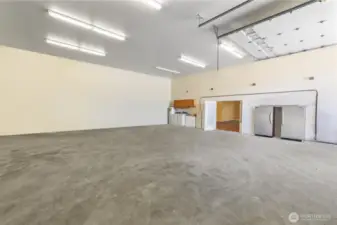 Huge shop holds large RV. Built-In Shelving not seen here stays. The French doors lead to the Studio. Washer/Dryer hook-ups for extra laundry capability.