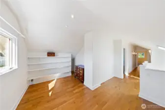 Here is the Art Studio Space.  The space behind is where the built-in storage cabinets are.  The stairs are on the other side of the Pony Wall on the right.  There is additional storage tucked behind the built in shelving on the right side.  You can see the first door on the left opens to a large Bedroom with walk-in closet.  The second upper Bedroom is seen at the end of the hallway.