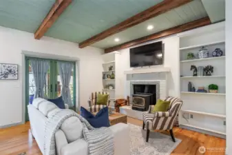 Who says you can't have it all? We LOVE the warmth of wooden beams, the wood burnng fireplace, the scale of the room, the French Doors, the wood flooring, the bookshelves and a place to watch a movie or the game!