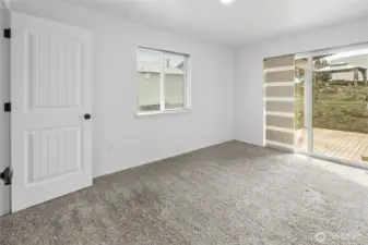 Primary bedroom with glass sliding door to the covered deck.