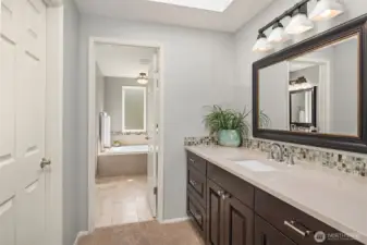 One of 2 vanities in the primary suite. To the left is the door to walk-in closet with custom shelving
