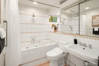 Full en-suite primary bath with soaking tub & pedestal sink.