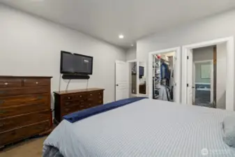 Looking across the primary suite with the large walk-in closet and full bath with a separate jetted tub and dual headed shower.