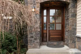 The front entry door is just stunning and has obscured glass and is surrounded by stone.