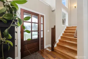 The entry is well-defined and has soaring ceilings. The stairway has plank stairs and makes a true statement.