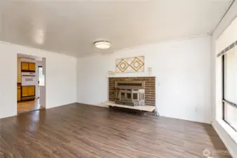 Bright living room features a wood-burning fireplace