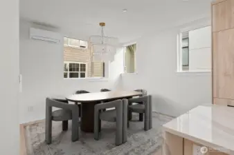 Above, the entry level sports a deluxe kitchen with expansive dining area. This image is virtually staged.