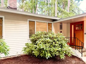 Welcoming front entry framed by lush greenery