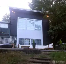 Floor-to-ceiling windows showcase sweeping views of the home’s expansive grounds.