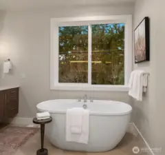 Luxurious soaking tub positioned beneath oversized windows.
